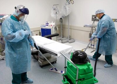 Two People Moping Floor in Medical Examine Room
