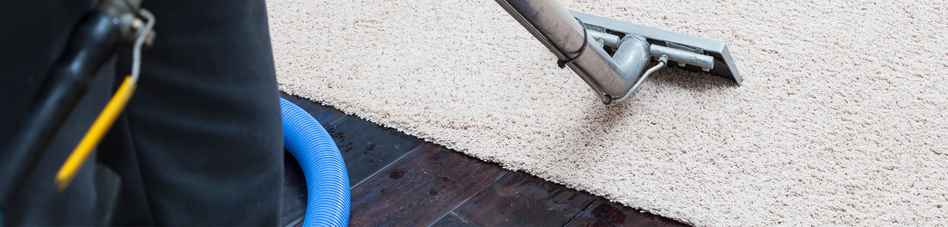 ServiceMaster Clean professional performing commercial area rug cleaning service on a beige rug with an industrial rug cleaner machine