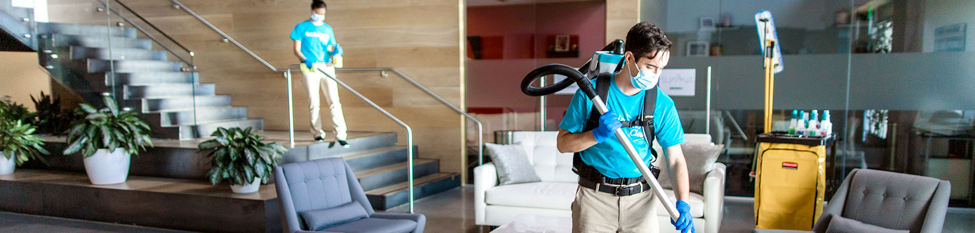 Two cleaning people cleaning an multi level office foyer during business hours
