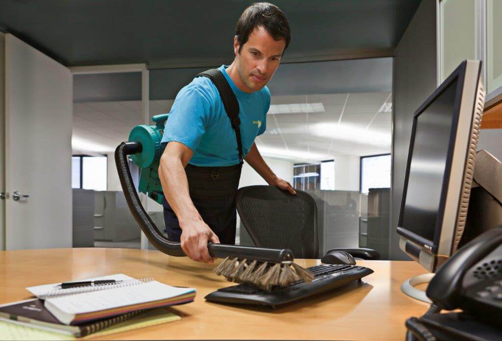 Janitor wiping down an office desk chair