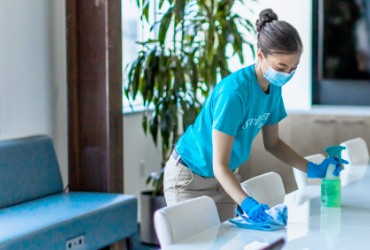 ServiceMaster Clean professional cleaning a conference room table with green solution