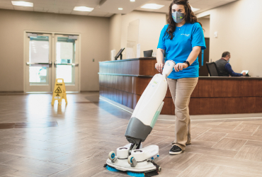 woman mopping floor of a lobby area in a houston office