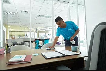 A ServiceMaster expert sanitizing a conference table during janitorial services in Lima, OH