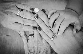 black and white photo of three adult and one child hands