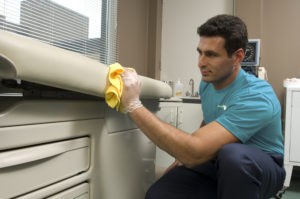 Person cleaning the exam table